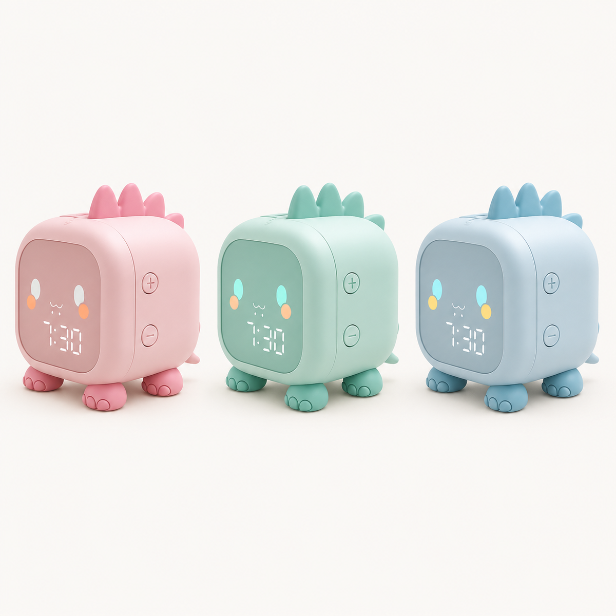 Les trois coloris du réveil veilleuse enfant Dino de Nox et Dies : rose, vert menthe et bleu, présentés côte à côte.