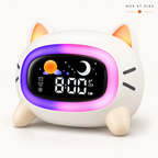 Réveil veilleuse enfant Miaou Nox et Dies en forme de chat blanc aux oreilles orangées, halo lumineux violet et rose allumé et écran LED affichant l'heure