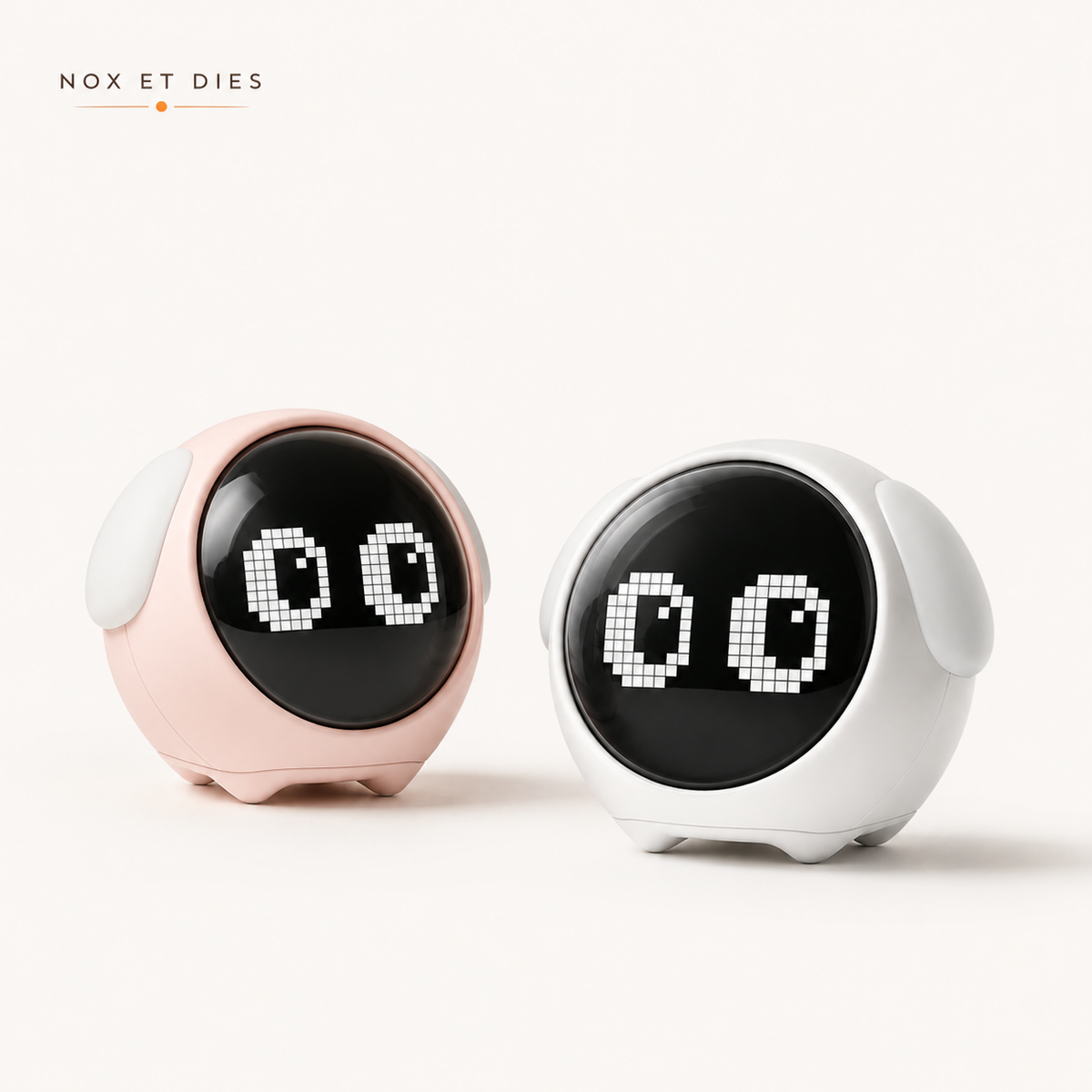 Réveils veilleuses Mimi Nox et Dies coloris rose et blanc vus de trois-quarts, écrans affichant une expression d'yeux animée