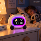 Réveil veilleuse enfant Panda Nox et Dies sur une table de chevet, halo violet allumé et icône lune affichée pendant qu'un petit garçon dort avec sa peluche panda