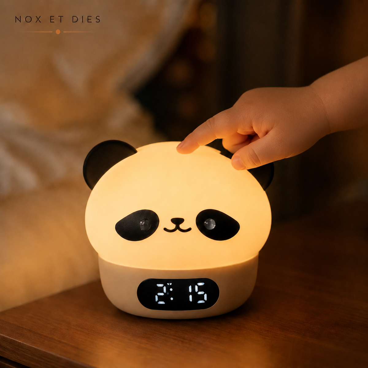 Main d'enfant tapotant délicatement la veilleuse réveil Pandino Nox et Dies pour allumer la lumière