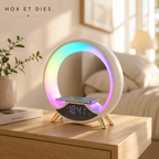 Lampe d'ambiance Piédor aux couleurs dégradées, avec téléphone en charge sans fil sur une table de chevet